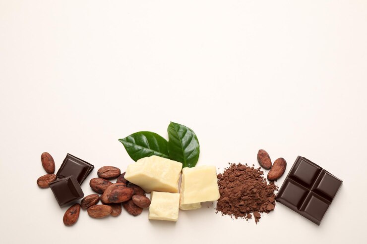 Explore a delicious guide to assorted chocolate ingredients on a light background, featuring dark chocolate pieces, cocoa beans, white chocolate chunks, cocoa powder, and two green leaves. Whether it's 2024 or beyond, indulge in the classic allure of these mouthwatering treats.