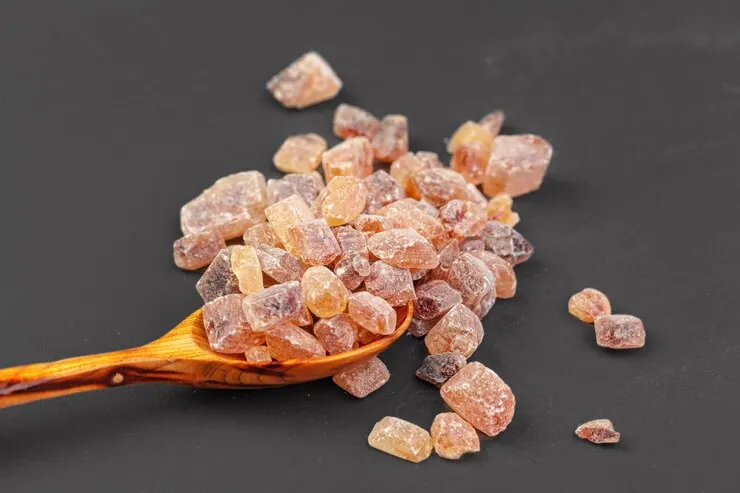 "A close-up shot of peach gum displayed in a small bowl. The pieces are amber-coloured with a glossy, crystalline appearance, highlighting their unique texture and natural beauty.