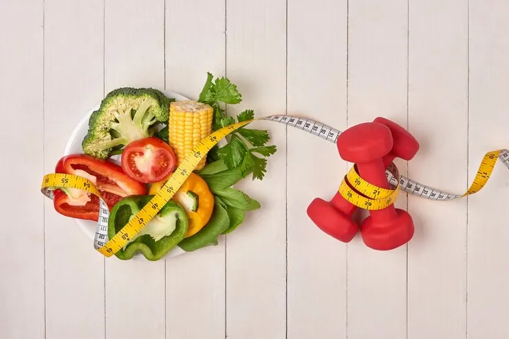 Bell pepper with measuring tape dumbbells bottle water isolated white