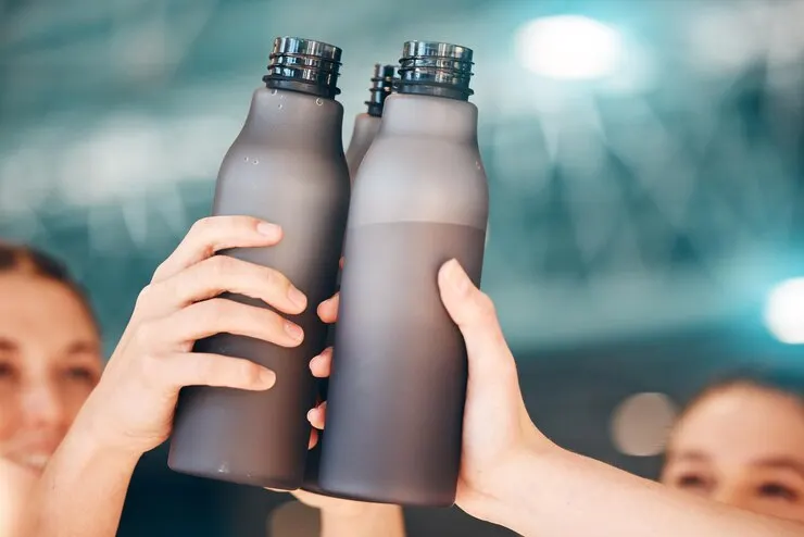 Hands fitness cheers with bottle water team training exercise workout achievement sports hand sport group celebration touching bottles drinking hydration winning unity
