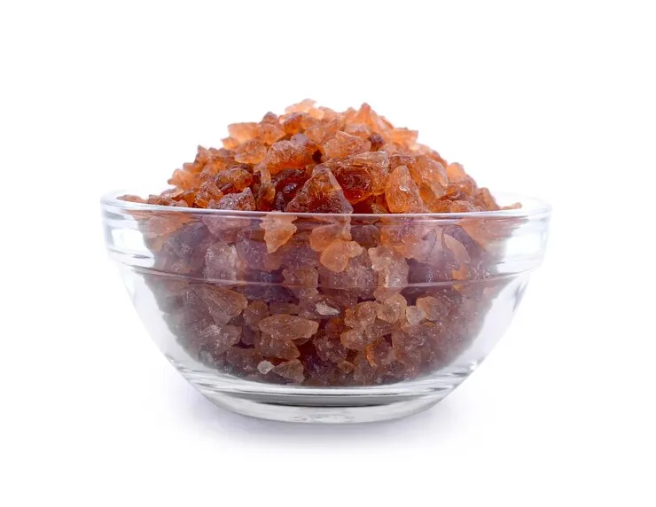 A close-up shot of peach gum, displayed in a small bowl. The peach gum pieces are amber-coloured and have a glossy, crystalline appearance, emphasising their unique texture and natural beauty.