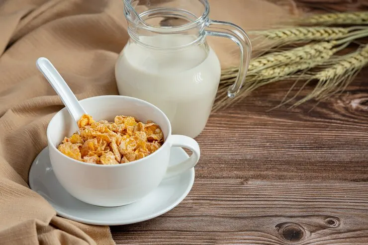 Oat milk being poured over a bowl of cereal
