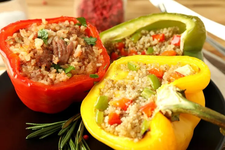 Vegan stuffed bell peppers filled with a savoury mixture of meat alternatives and fresh vegetables, beautifully arranged on a plate.