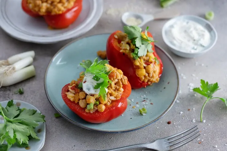 Vegan stuffed bell peppers filled with chickpeas and garnished with fresh cilantro, showcasing vibrant colours and textures.