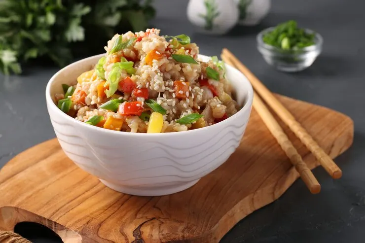 Fried rice with vegetables garlic ginger green onion wooden board dark background asian cuisine vegetarian food