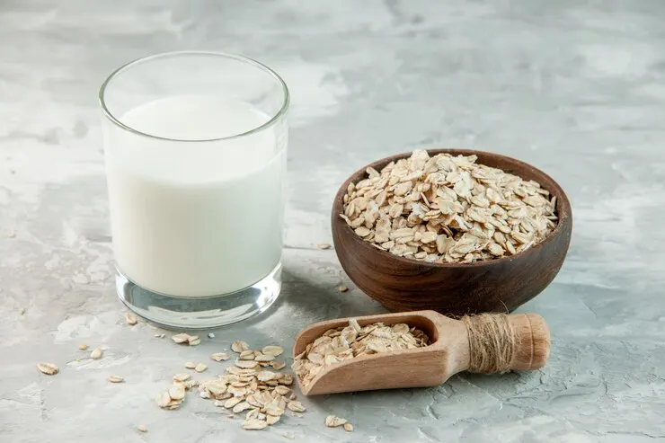 A bowl of oats with oat milk on a grey background, ideal for a nutritious breakfast cereal. 