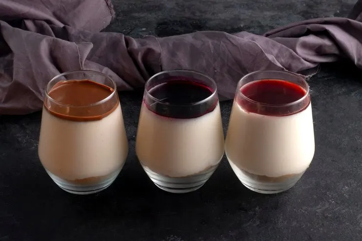 Three glasses of date-sweetened chocolate panna cotta in vibrant colours, perfect for a Valentine's Day celebration.