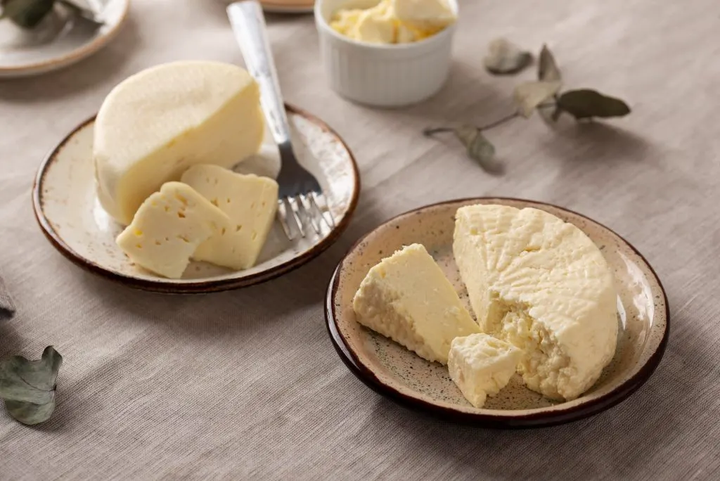 Butterkäse-style cheese wedges on rustic plates, used as inspiration for TikTok’s viral Butterkäse potato made vegan