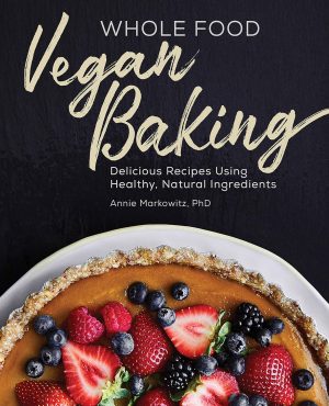 Cover of a cookbook titled "Whole Food Vegan Baking" by Annie Markowitz, PhD. The cover spotlights a large pie topped with fresh berries against a dark background, embodying the essence of vegan baking. Subtext reads: "Delicious Recipes Using Healthy, Natural Ingredients.