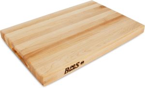 A rectangular, light-colored John Boos wood cutting board with a smooth surface. This reversible board showcases natural wood grain patterns and features a branded "Boos" logo on the side.