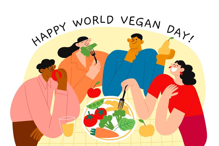 Illustration of a diverse group of people enjoying fresh vegetables and fruits at a table, with the text 'Happy World Vegan Day!' celebrating plant-based eating and community.