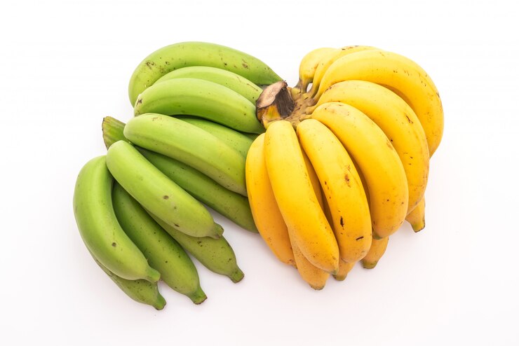 "Two bunches of bananas, one with unripe green bananas and the other with ripe yellow bananas, displayed side by side on a white background, illustrating the different stages of ripeness."