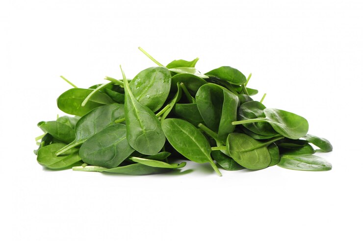 "Pile of fresh spinach leaves on a white background, highlighting their vibrant green color and crisp texture, representing a nutritious leafy green vegetable rich in vitamins and minerals."