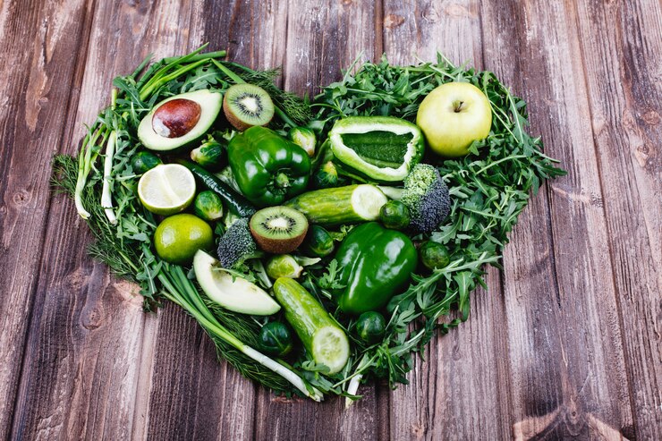 A collection of heart-shaped vegetables arranged on a rustic wooden table, showcasing vibrant colors and unique shapes.