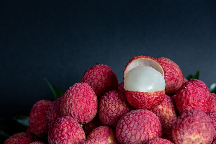 A close-up shot of red lychee fruits placed in a basket. The lychees' vibrant red color and rough texture are clearly visible, highlighting their fresh and appealing appearance.