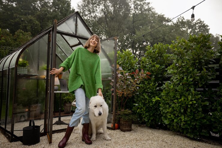 A woman with her dog in a backyard, both enjoying the outdoor space surrounded by greenery. The woman is interacting affectionately with her pet, creating a warm and relaxing atmosphere in a place where she can grow her own food.