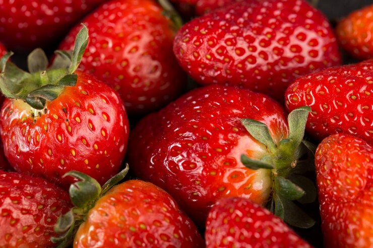 "Close-up of fresh, ripe strawberries with vibrant red color and green leaves, showcasing their juicy texture and natural sweetness."