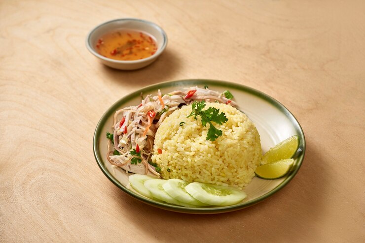 A plate of crispy rice salad with vegetables, garnished with chili garlic paste, set on a rustic wooden table.