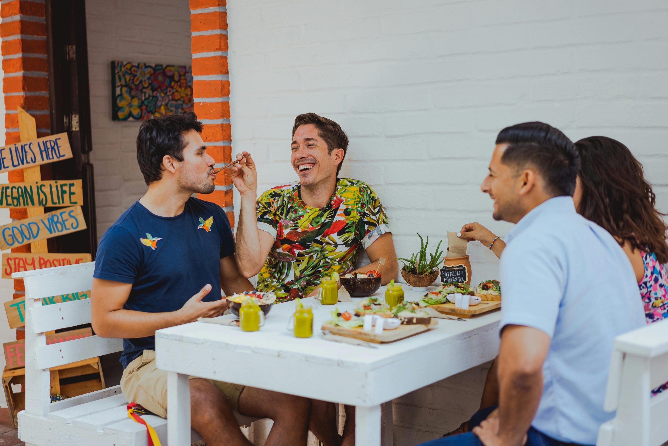 A diverse group of individuals enjoying a meal together at a table, showcasing the vibrant atmosphere of vegan dining.