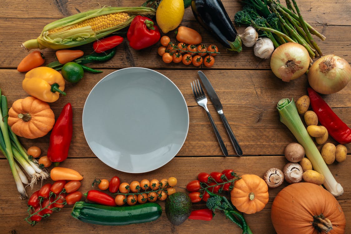 A plate filled with assorted vegetables, paired with a knife and fork, representing a gluten-free vegan diet for weight loss. Nutritious and delicious.