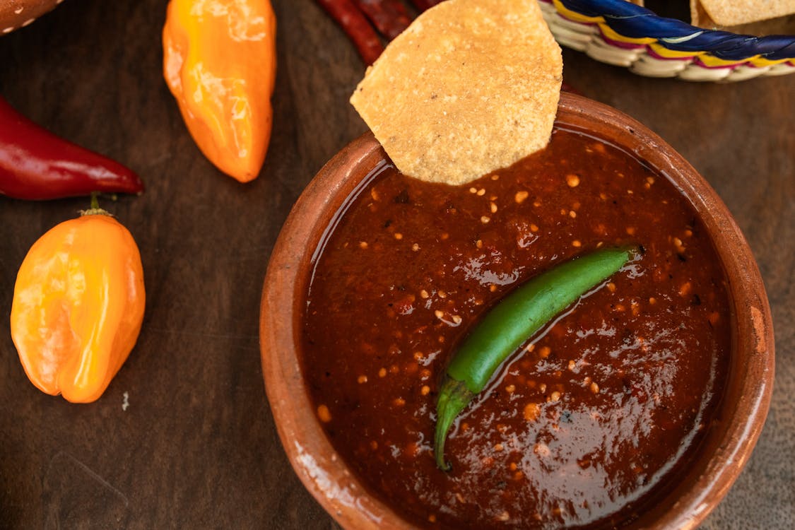 A vibrant display of Mexican food featuring chips and salsa, highlighting jalapeno measurements and alternatives in the recipe.
