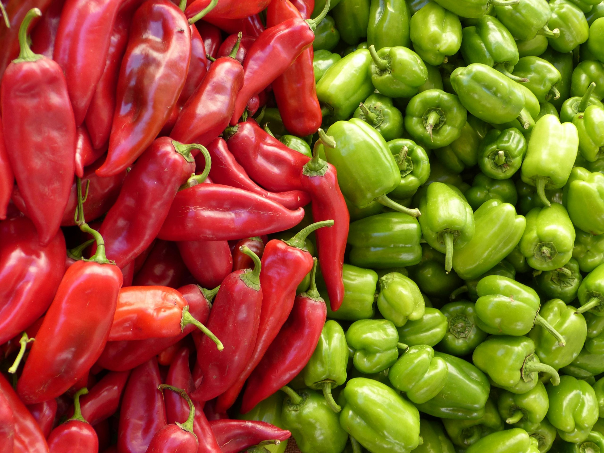 A vibrant assortment of red and green peppers as an alternative to jalapeno measurements stacked together, showcasing their fresh and colorful appearance.