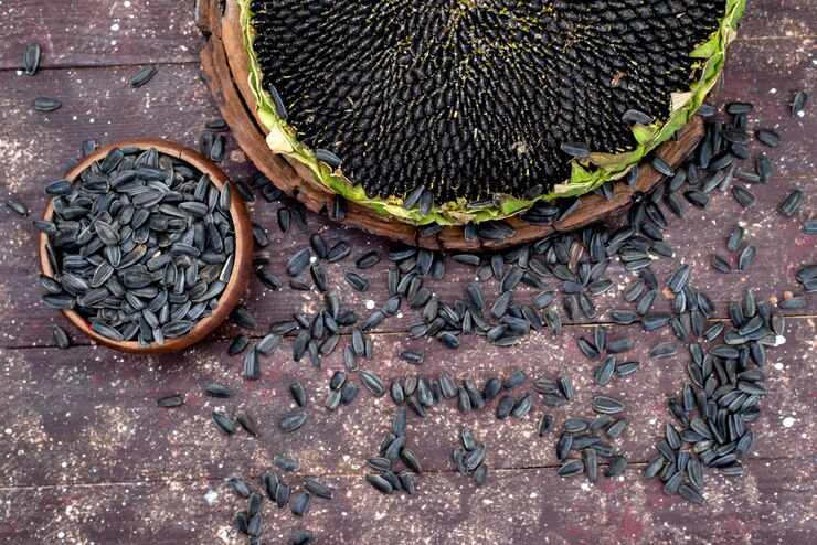 A close-up of sunflower seeds scattered on a wooden table, highlighting their appeal as a vegan protein source.