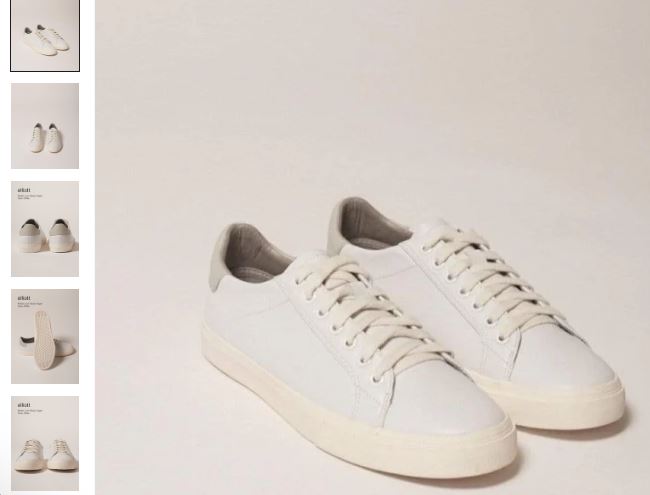 A pair of classic white vegan leather sneakers featuring laces and a white leather sole, designed by Elliott.