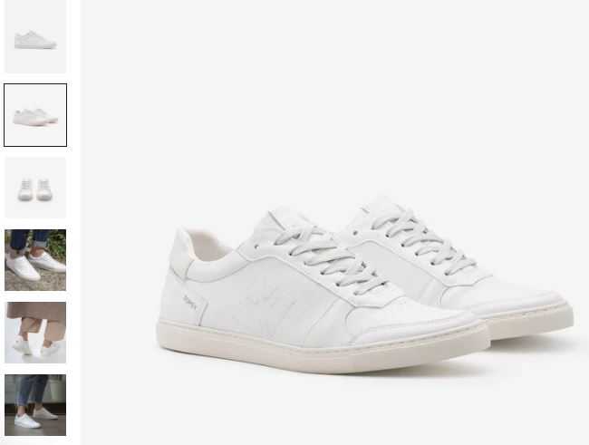 A white leather sneaker with a white sole, featuring a sleek design from COG's Topsy Unisex Grape Leather Vegan Sneakers.