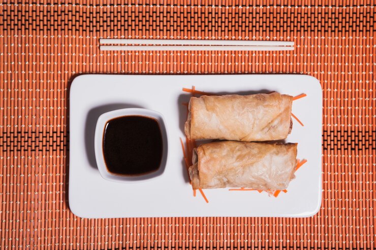 Delicious vegan spring rolls served with dipping sauce on a white plate, creating a delightful Valentine's Day dining experience.