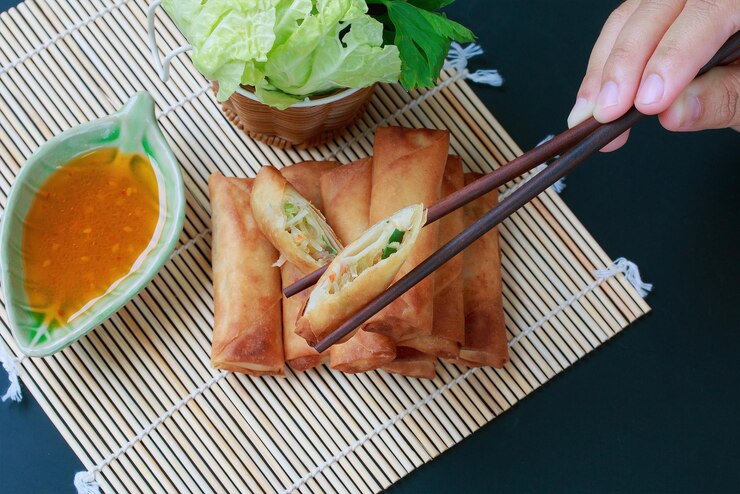 A plate of vegan spring rolls served with a vibrant dipping sauce, perfect for a memorable Valentine's Day celebration.