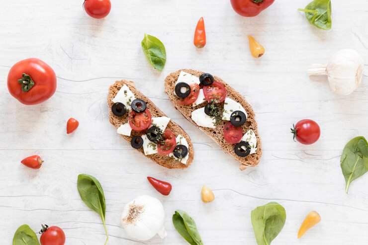 Two slices of bread featuring cheese, tomatoes, and basil, showcasing a vibrant vegan bruschetta for Valentine's Day celebration.