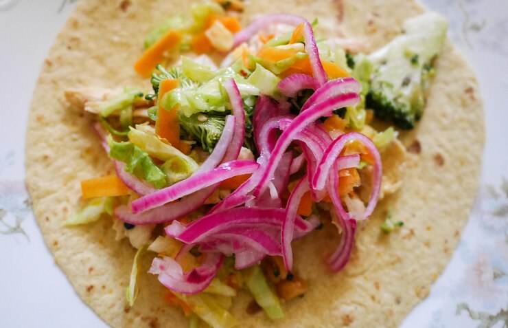 A colorful taco topped with vegetables and onions, highlighting the essence of the best vegan cauliflower tacos.