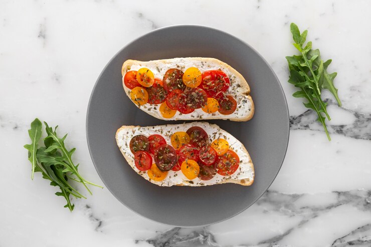 A plate featuring two slices of bread adorned with vibrant tomatoes and herbs, perfect for a romantic vegan bruschetta.
