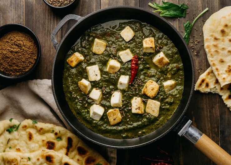 A pan of Easy Saag Tofu with spinach, set on a wooden table, ideal for a cozy Valentine's night dinner.