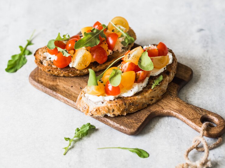 Vegan bruschetta featuring tomato, mozzarella, and basil, beautifully arranged on a wooden board for a romantic touch.
