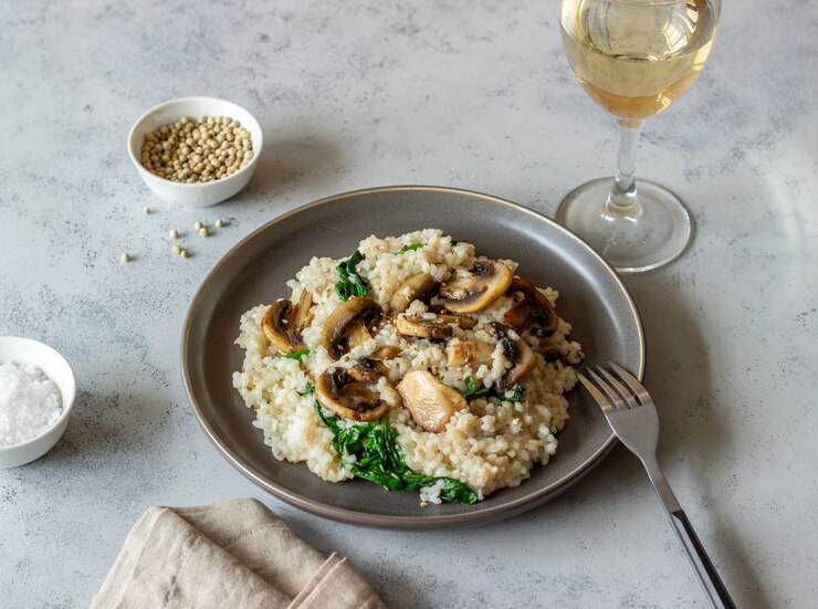 A bowl of vegan mushroom risotto featuring spinach and parmesan, showcasing a quick and easy recipe for a wholesome dish.