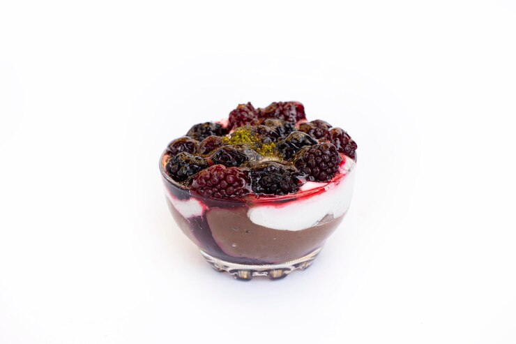 A decadent chocolate raspberry parfait topped with fresh blackberries and a dollop of cream, perfect for Valentine's Day.