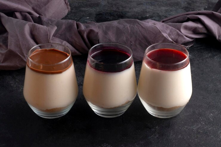Three glasses of date-sweetened chocolate panna cotta in vibrant colors, perfect for a Valentine's Day celebration.
