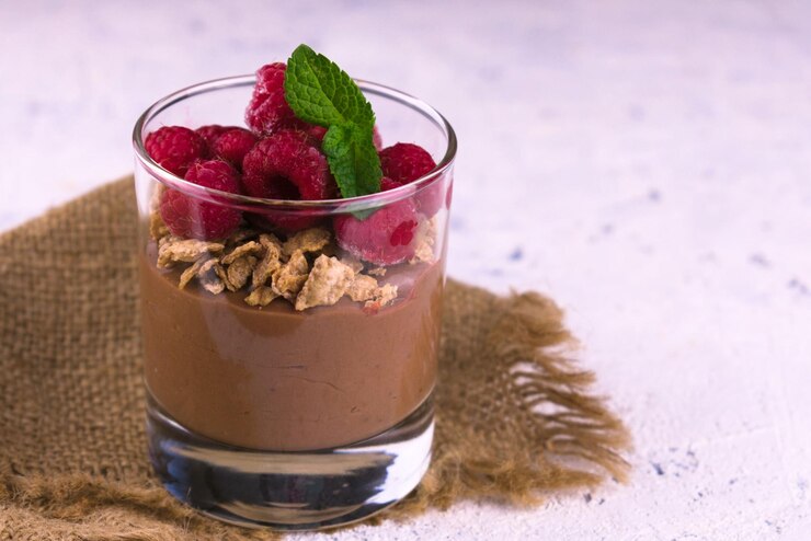 Chocolate Raspberry Parfait layered with raspberries and granola, elegantly presented on burlap cloth for a romantic Valentine treat.