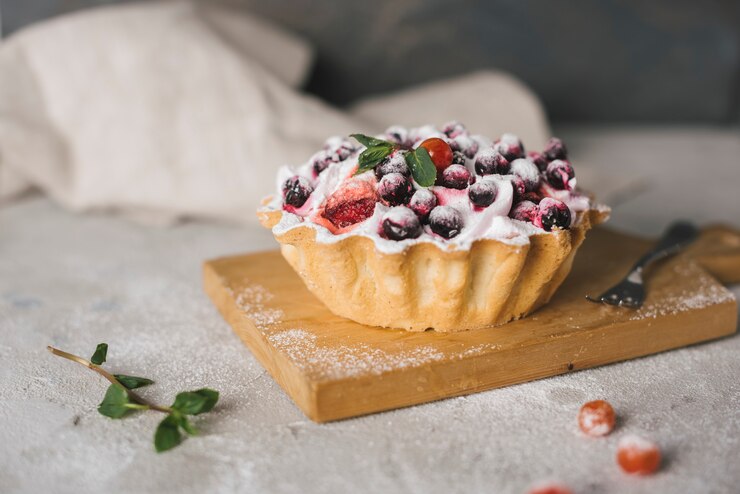 A romantic dessert featuring blueberry tartlets topped with fresh berries and whipped cream, perfect for Valentine's Day.