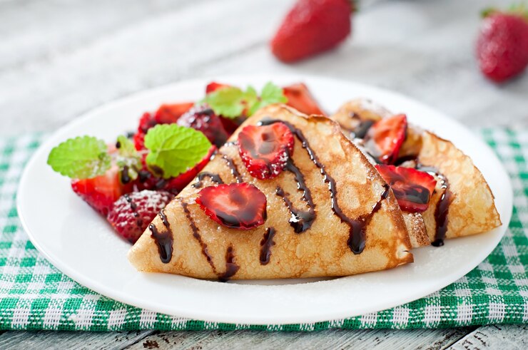 Vegan Palacinky strawberry crepes drizzled with rich chocolate sauce, perfect for a romantic Valentine's Day treat.