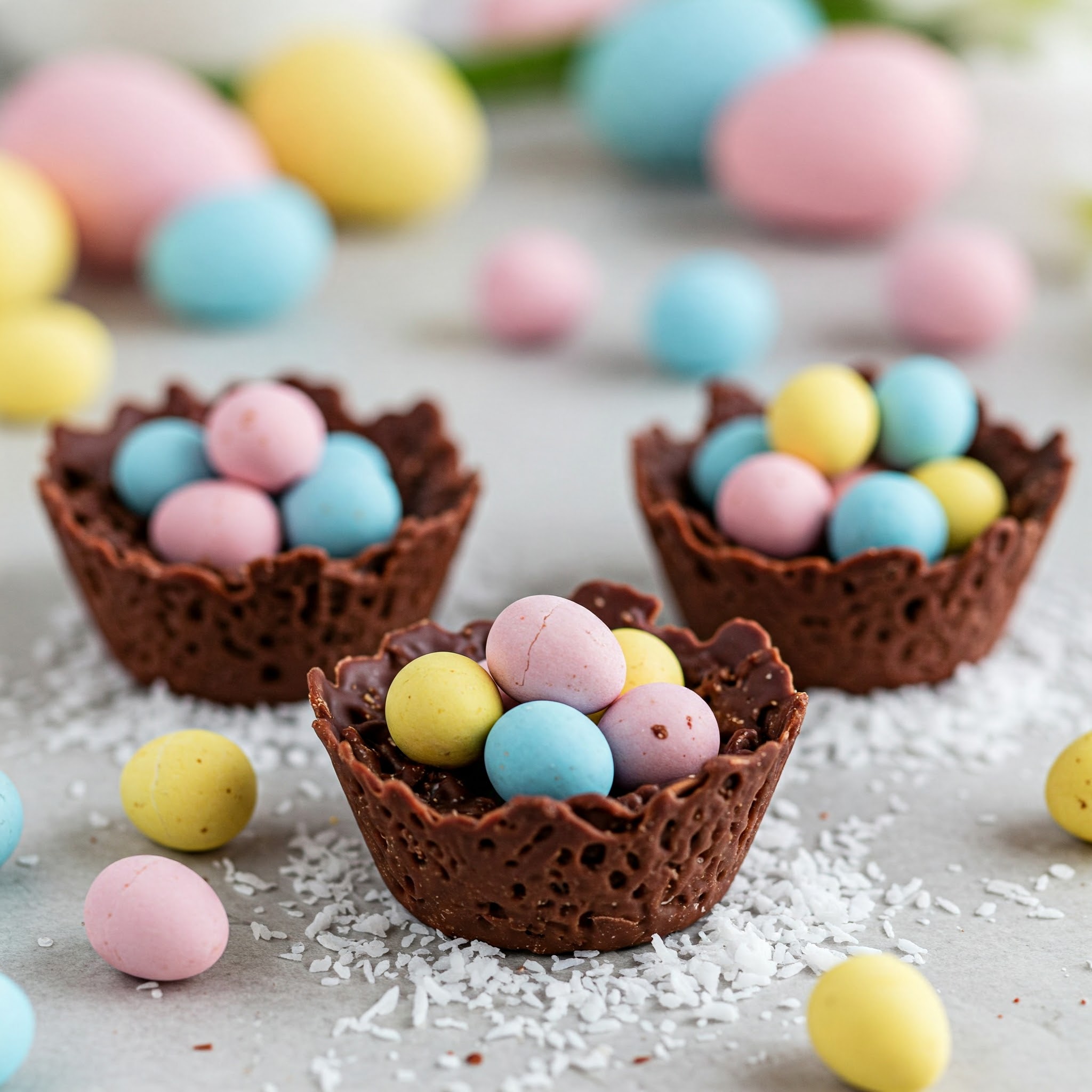 Vegan chocolate nests topped with colorful eggs, perfect for Easter treats.
