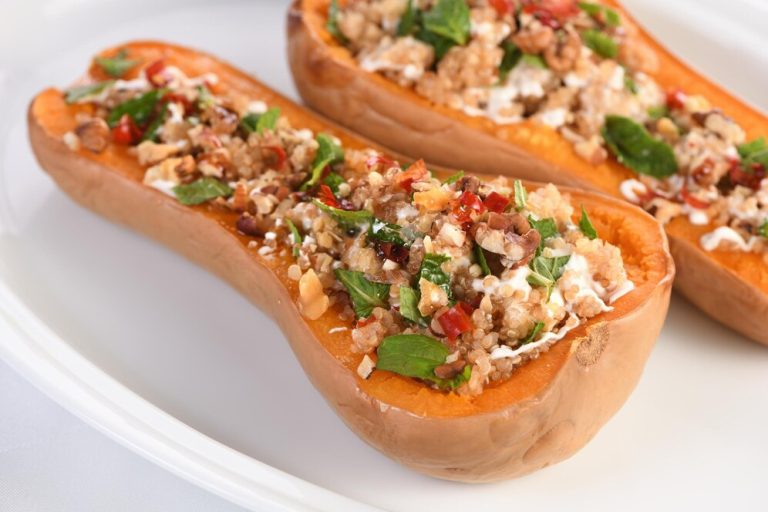 Two stuffed butternut squash halves filled with cheese and herbs, presented as a summer recipe idea.