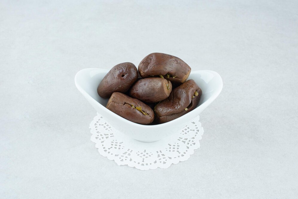 A bowl of chocolate-covered nuts, featuring a delightful vegan snack in the context of trending pistachio-stuffed dates.