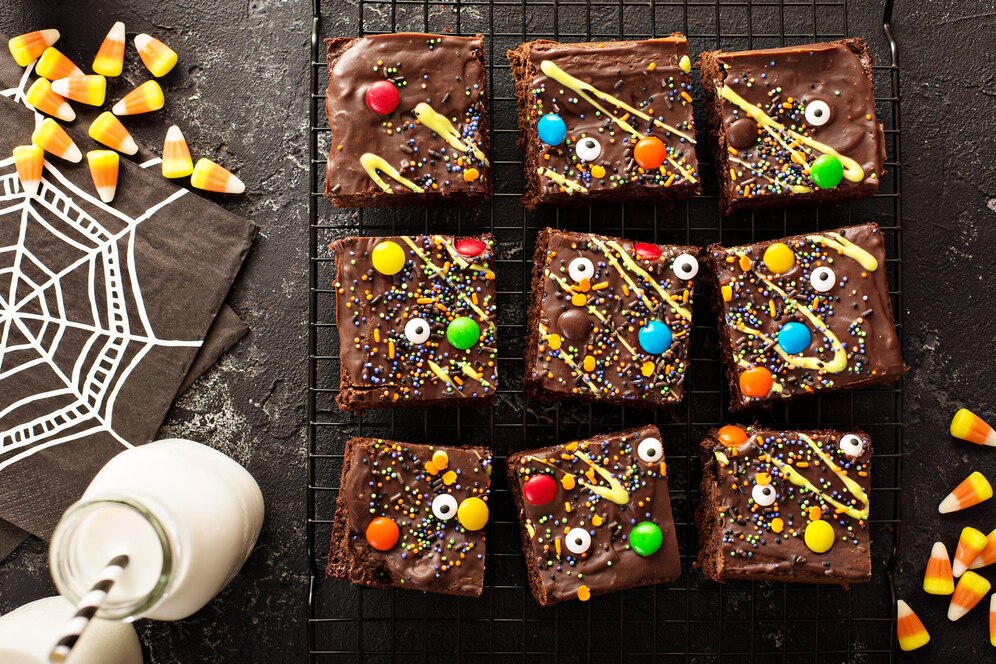 Festive vegan brownies adorned with candy corn and assorted candies, offering a modern twist on classic Cosmic Brownies.