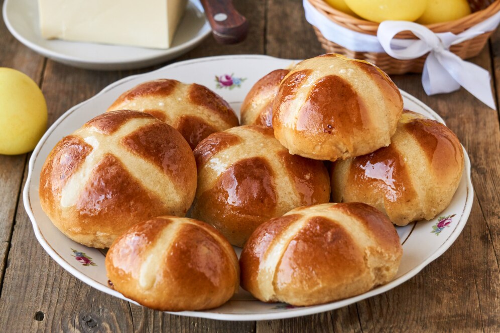 A serving of vegan hot cross buns with butter and eggs, ideal for an easy Easter brunch.