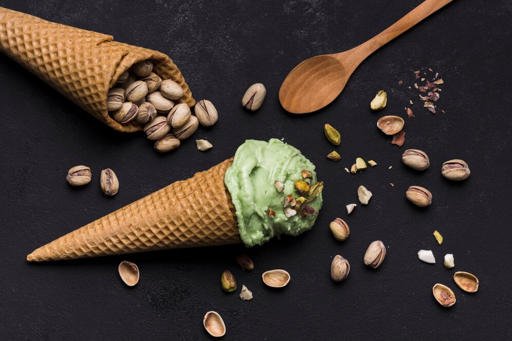 Green pistachio ice cream topped with nuts, set against a black background, showcasing a viral vegan recipe.